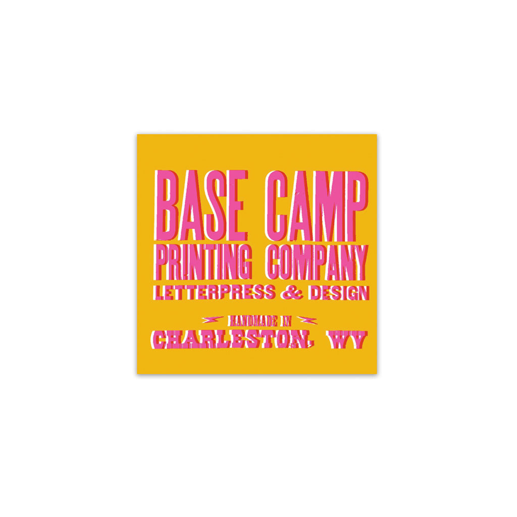 A sticker with a yellow background featuring the text 'BASE CAMP PRINTING COMPANY' in pink and 'CHARLESTON, WV' in smaller text below. The sticker has a vibrant design.